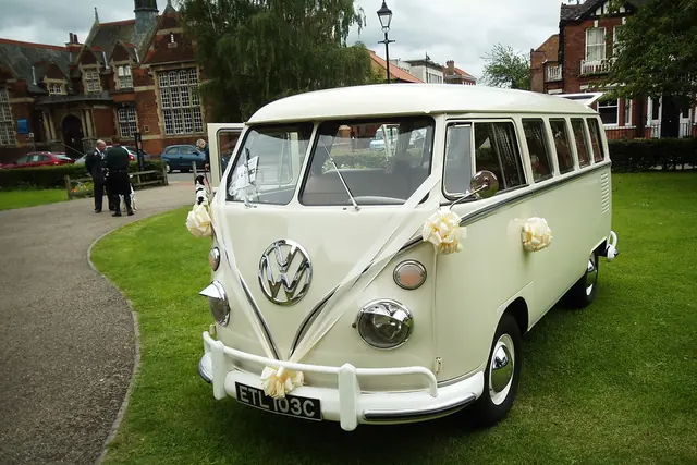 Furgón clásico decorado con cintas y flores blancas para un matrimonio