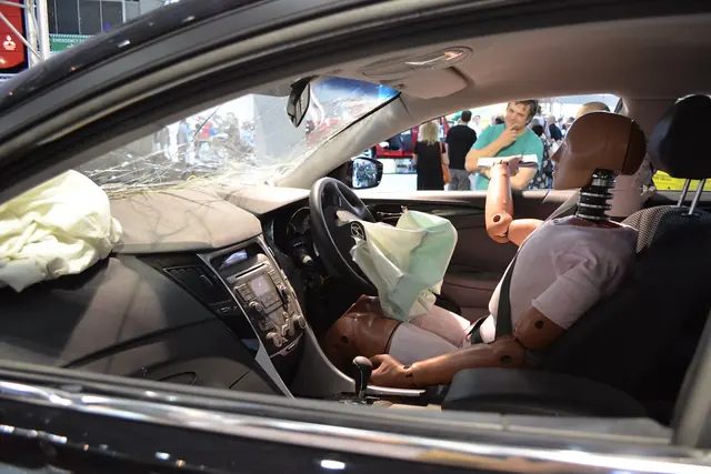Maniquí de pruebas de choque sentado en un auto con el airbag desplegado
