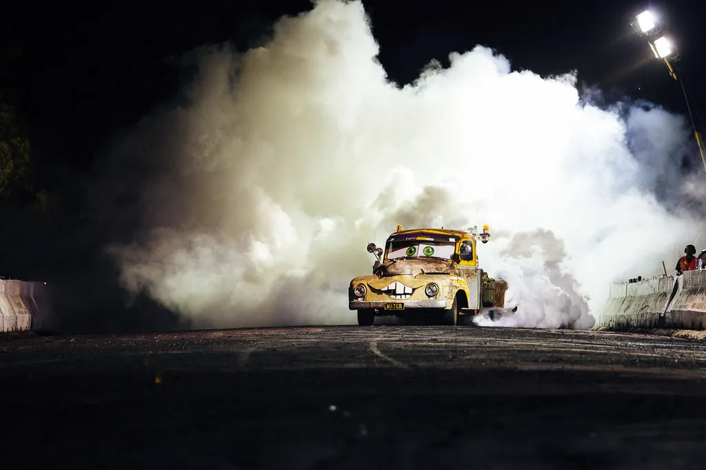 Auto quemando neumáticos de noche entre una gran nube de humo