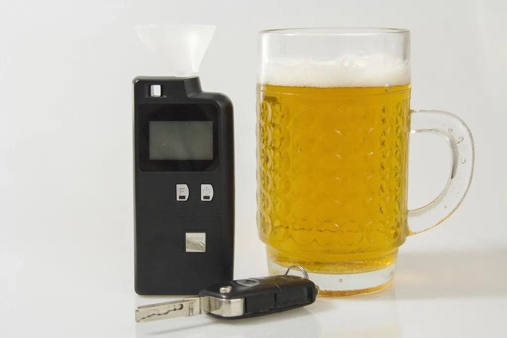 Un alcotest junto a un schop de cerveza y las llaves de un auto